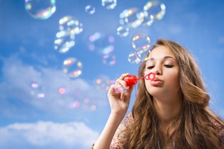a woman blowing bubbles in the air