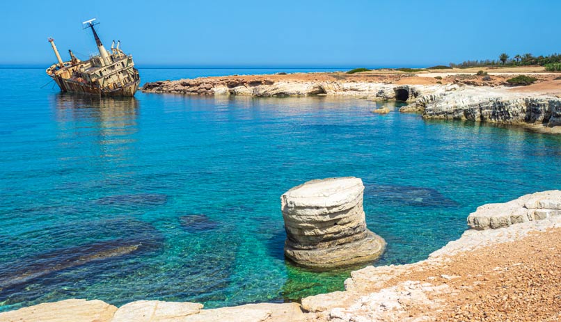 חוף בפאפוס וברקע ספינה נטושה