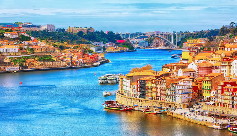 Porto, Portugal old town ribeira aerial promenade view with colorful houses, Douro river and boats